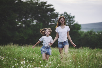 Fototapeta premium mother and daughter running in the field