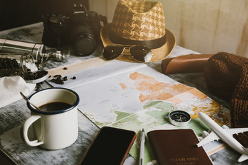 Naklejka premium Tourist planning vacation with the help of world map and compass along and Coffee cup with coffee grinder with other travel accessories. Preparing for travel. Travel planning concept holiday with map.