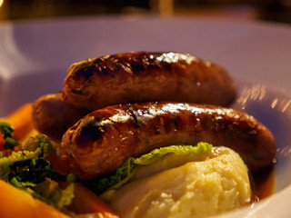 Closeup macro detail of a plate of Bangers and Mash, a traditional dish consisting of fried sausages and mashed potatoes, at a pub. London, England. Travel and cuisine. - 289520185