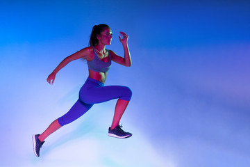 Fototapeta na wymiar Side view of athlete training with blue background