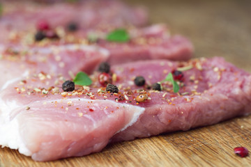 Steaks sprinkled with spices and herbs. Juicy steaks for a barbecue close up.