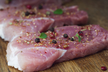 Steaks sprinkled with spices and herbs. Juicy steaks for a barbecue close up.