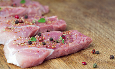 Steaks sprinkled with spices and herbs. Juicy steaks for a barbecue close up.