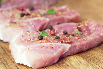 Steaks sprinkled with spices and herbs. Juicy steaks for a barbecue close up.