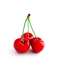Colorful three delicious cherries, isolated on white background, natural shadow.