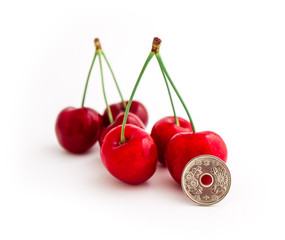 Fresh cherries isolated on white background, with Japanese coin. Food consumption, international...
