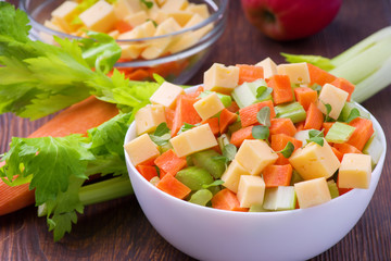 Fresh salad from stalks of celery, carrots, apples and cheese. Fitness breakfast, healthy.