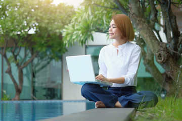 Asian Woman sitting to use laptop at park outdoor