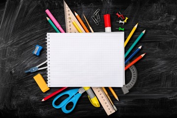 Plakat Colorful school supplies on wooden table background