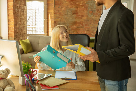 A young businesswoman moving in the office, getting new work place. Young female office worker meets her colleague or workmate after promotion, taking help. Business, lifestyle, new life concept.