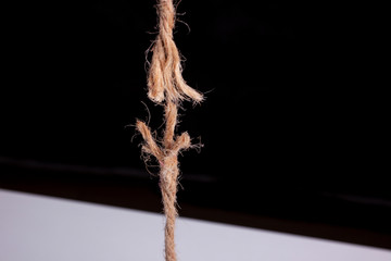 frayed rope ready to break on black background