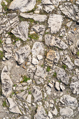 An old time damaged wall made of rough stone. Natural background for design.