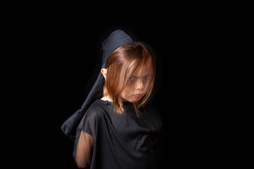 Divertido retrato de estudio de una niña de 5 años con un disfraz de halloween. Fondo negro