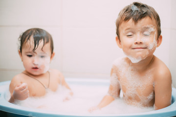 children, brother and sister in the bathroom swimming, playing splashing