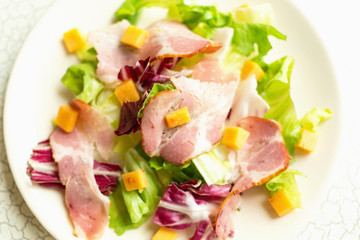 Plate of salad with green leaves, ham and cheese. Intercontinental breakfast at the hotel. Dietary lunch.