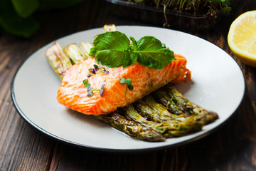 Grilled salmon and asparagus with lemon on the white plate