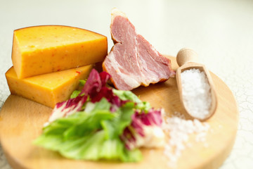 Fresh lettuce, cheese, ham and sea salt on a cutting board. Intercontinental breakfast at the hotel.
