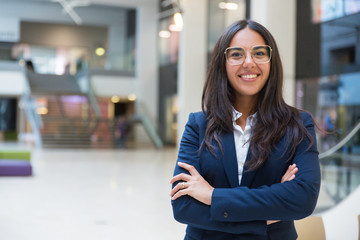 Young businesswoman smiling at camera. Portrait of cheerful Hispanic businesswoman in formal wear...