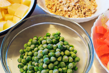 Frozen peas in a glass bowl on a wooden table