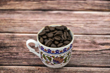 brown coffee beans in a blue Turkish coffee Cup