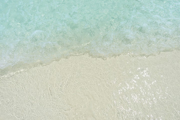 Close-up wave of blue sea on the beach.