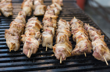 Delicious bbq grilling meat on open grill, outdoor kitchen. Food festival in city. tasty food roasting on skewers, food-court. Summer picnic.
