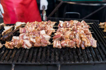 Delicious bbq grilling meat on open grill, outdoor kitchen. Food festival in city. tasty food roasting on skewers, food-court. Summer picnic.