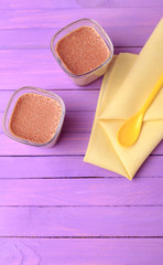Chocolate Yogurt. Two portions of chocolate milk dessert are on a wooden table of purple.