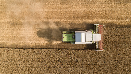 Aerial top down view shot of combine harvester harvesting field © dechevm