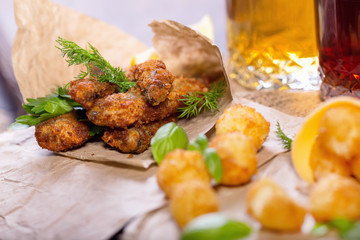 Beer snacks. Fried fried fish and cheese balls with lemon and greens. Snacks to different beers.