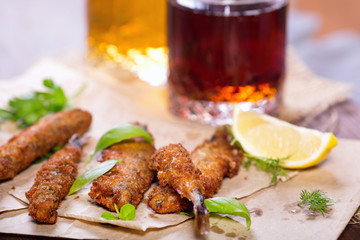 Fried anchovies in batter. Fried fish snack for beer. Mediterranean snack with greens and lemon.