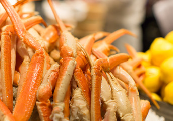 Seafood on ice, buffet line. Cooked king crab legs and lemons. Fresh seafood arrangement background. Crustacean gourmet dinner background. Delicious luxury dining restaurant holiday food arrangement.