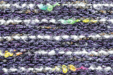 Background in the form of a product from wool of large knitting of white and violet color with a splash of yellow thread