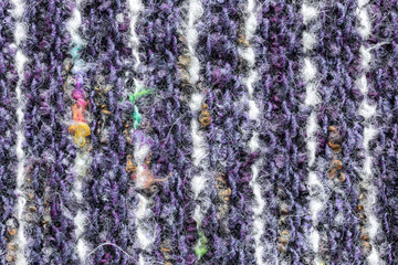 Background in the form of a product of wool of large knitting white and purple with a interspersed yellow thread vertically located