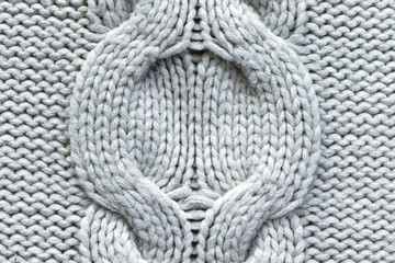 Background in the form of a white knitted wool product with a round pattern