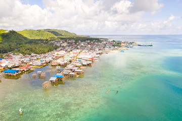 Fototapeta na wymiar Sea port in the city of Dapa, Philippines. Fishing village and ships, view from above. Seascape in sunny weather.