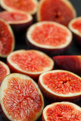 Ripe Figs. Creative diagram of chopped figs on a black textural background in the form of a texture inscribed in a rectangle