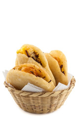 Arepa de huevo. Traditional Colombian fried arepa filled with egg and shredded meat on white background