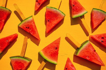 Fresh watermelon slices on the yellow background. Summer fruit concept.