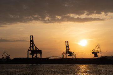 Fototapeta na wymiar Port cranes silhouette at sunset in Osaka Japan