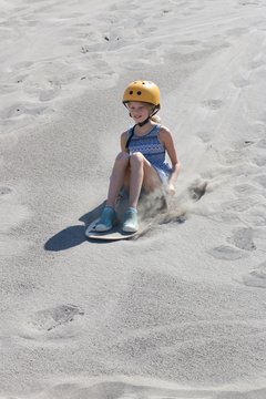 Closeup of a girl sand surfing down the Bruneau Dunes in Idaho, USA