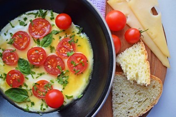 Fried eggs with tomatoes in a frying pan.Tasty and healthy food.