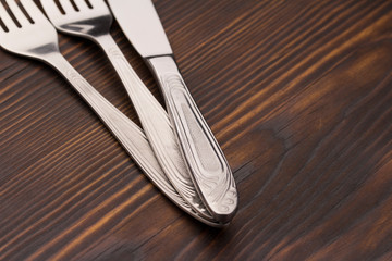 Cutlery Set. Spoon, Fork, Knife on a dark wood background. close up 