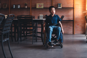 Obraz premium Disabled child on wheelchair play and learn indoors,Vintage style orange brick background,Special children's lifestyle,Life in the education age of special need children,Happy disability kid concept.