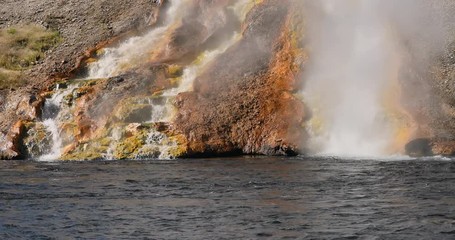 Yellowstone hot geyser waterfall into river. Geyser Yellowstone National Park in Wyoming, United States. Geothermal ecosystem feature. Caldera, super volcano. Biology geography and ecology.