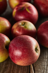 red juicy apples on brown wooden surface