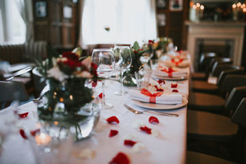 Wedding table setting decorated with fresh flowers and silverware. Concept of fine dining, catering and exclusive private hire of an event space.