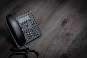 Closeup ip phone black color on the wood floor, Bussiness connection concept