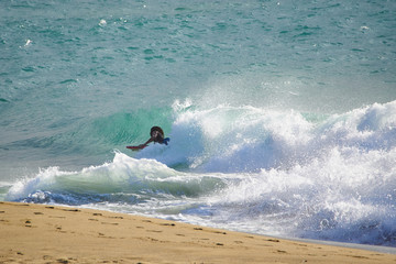 A black man caught a wave on the bodyboard of the Atlantic Ocean.