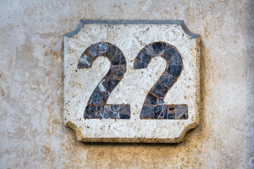 Number 22, twenty two, street number sign on the wall	